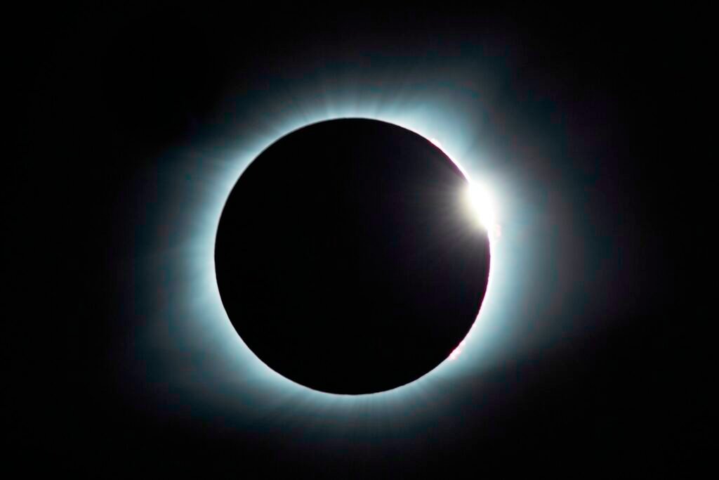 Éclipse solaire partielle observée à travers un ciel sombre.