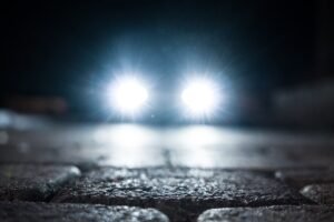 Phare de véhicule allumé la nuit dans la rue