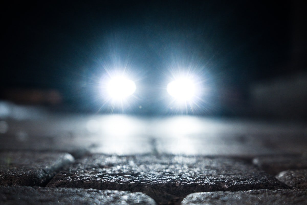 Phare de véhicule allumé la nuit dans la rue