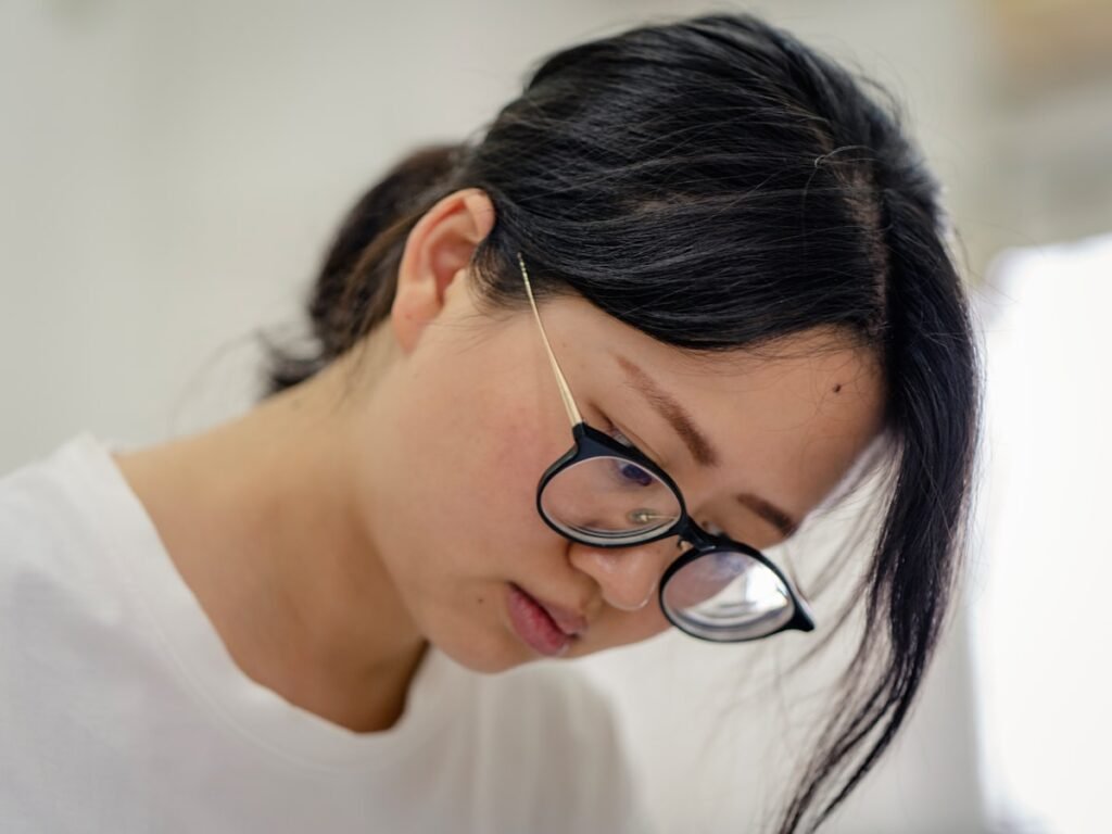 Femme portant des lunettes à monture argentée devant un ordinateur