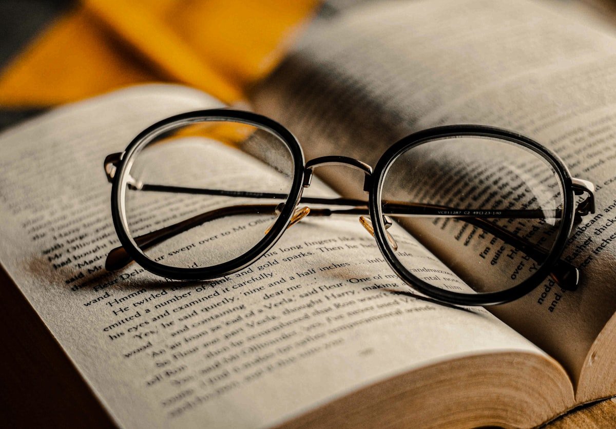 Lunettes à monture noire posées sur un livre ouvert