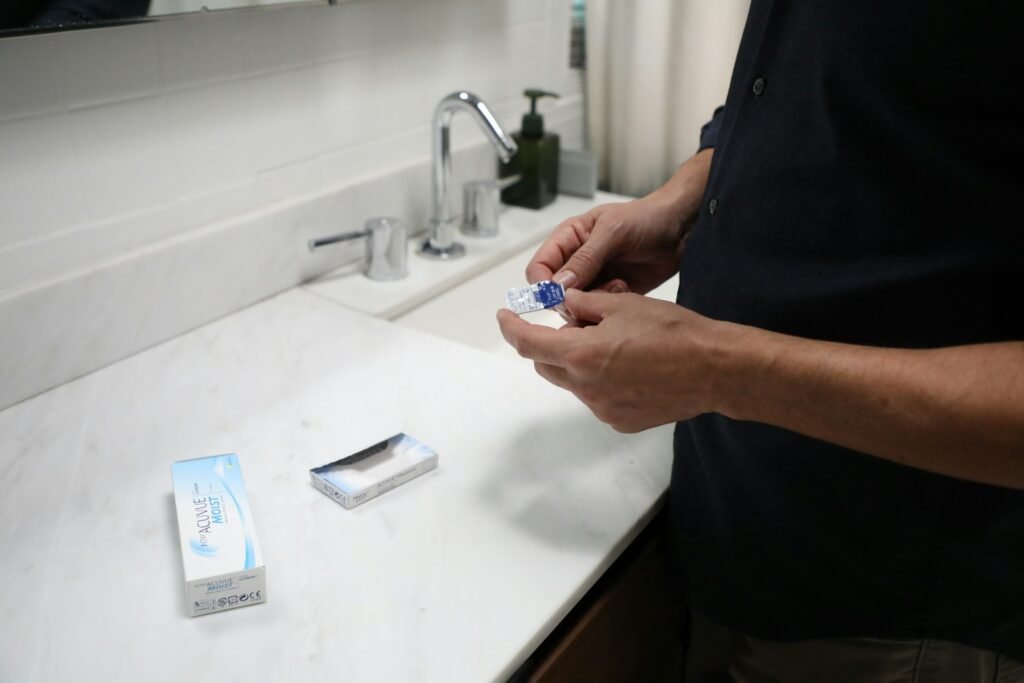 Personne tenant un blister de lentilles de contact souples journalières